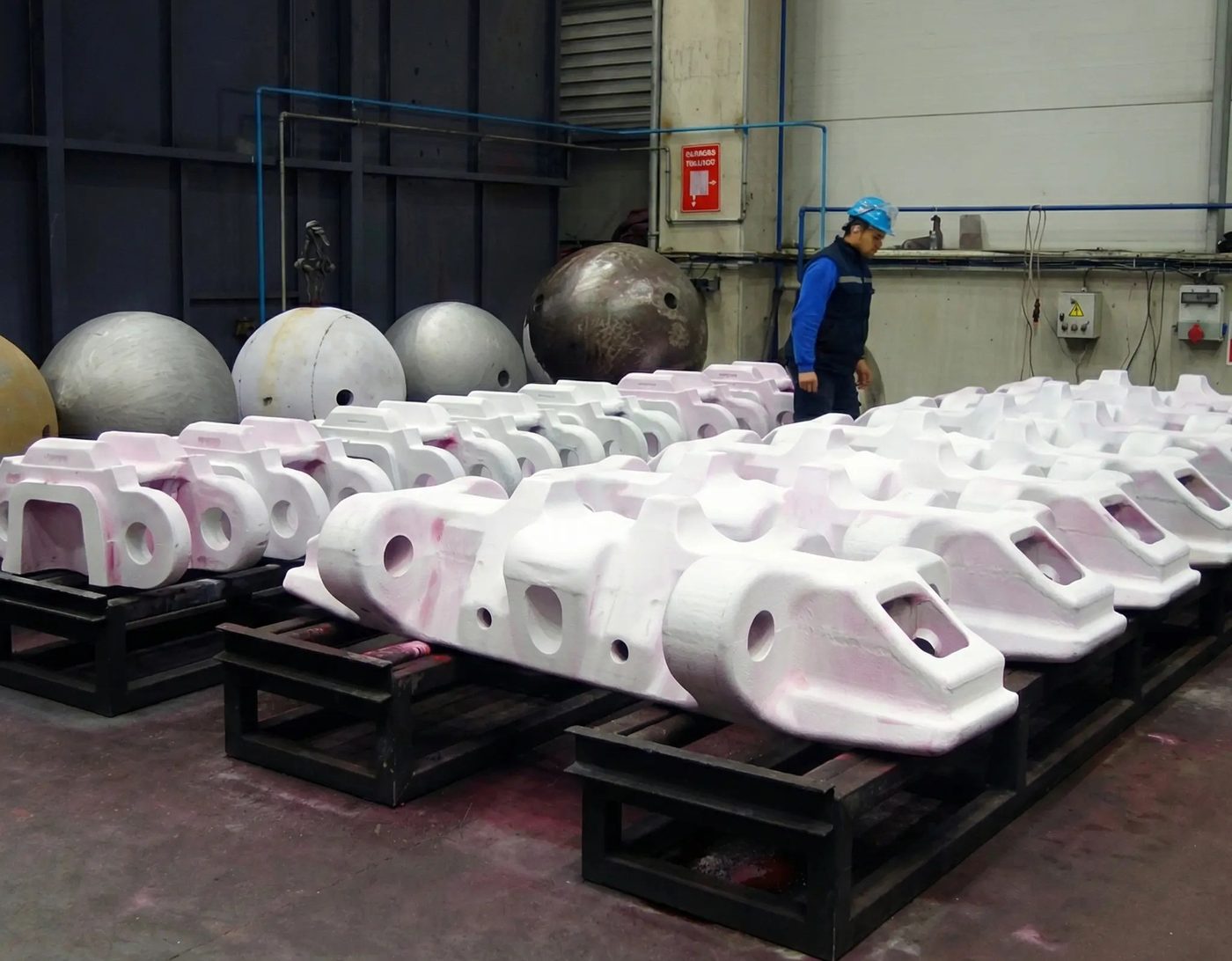 Serial cast steel components staged on transport frames after inspection