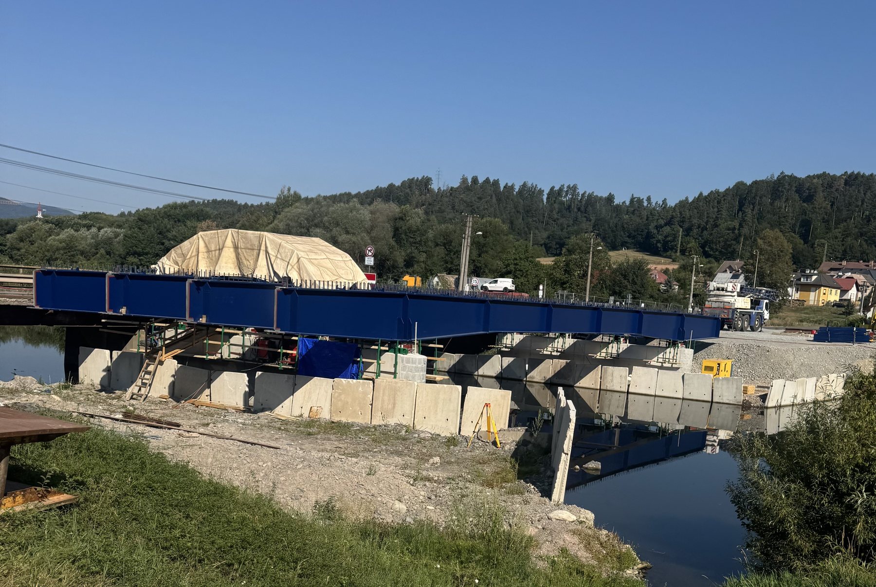 Full bridge span erected on temporary supports across a river